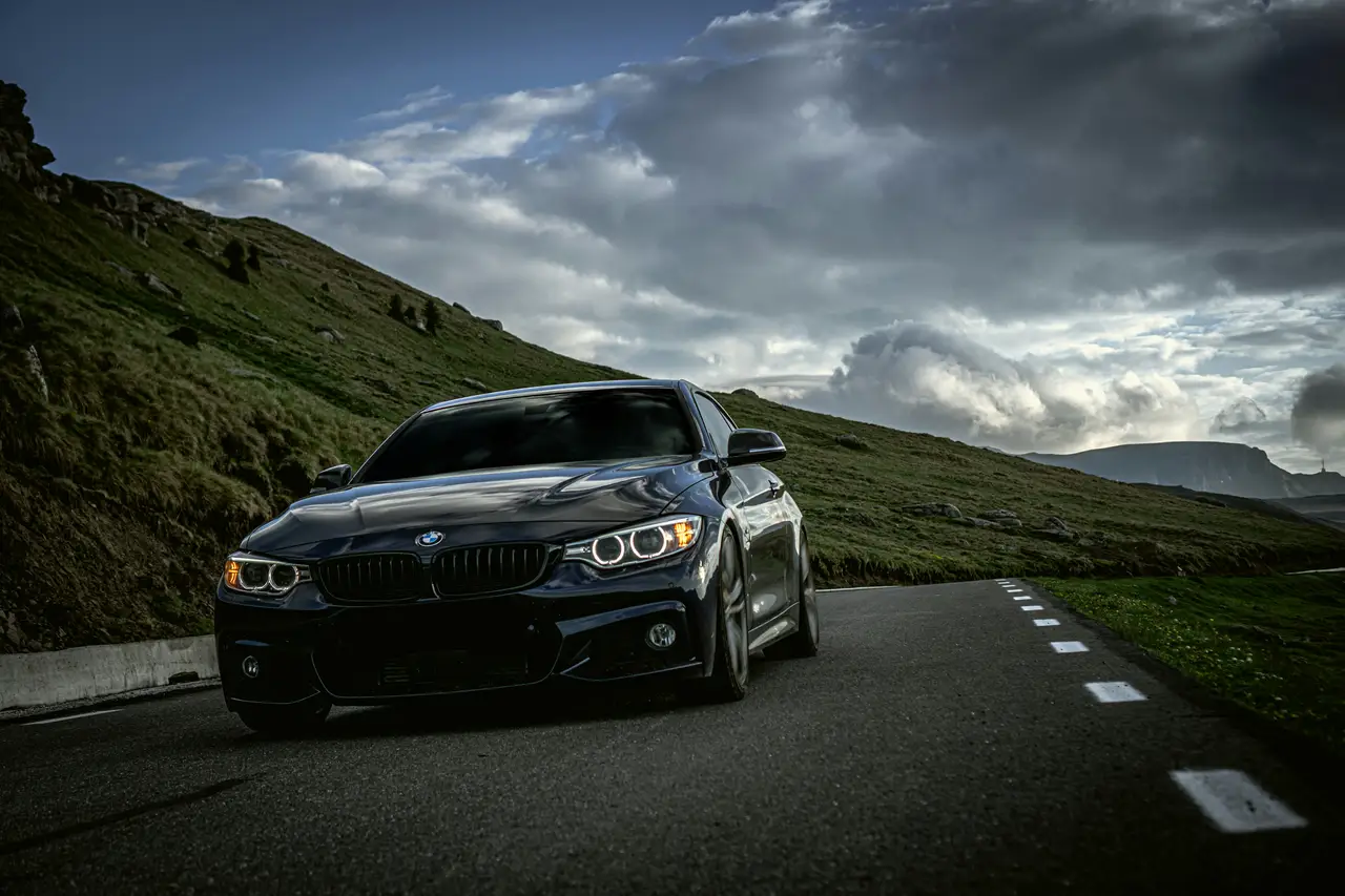 Black performance car on an open mountain road